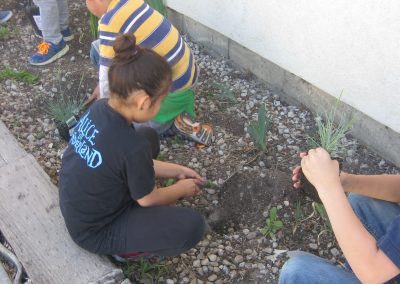 Husky Pride 4-H Club members planting flowers at Marsing Elementary School and District Office.
